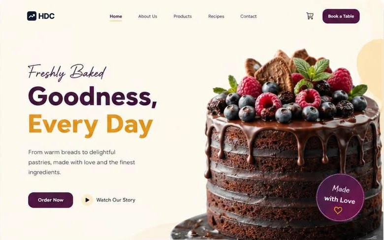 Bakery website design concept in cream and deep plum with gold accents, showing a script headline reading freshly baked goodness beside a photograph of pastries, bread and fresh berries